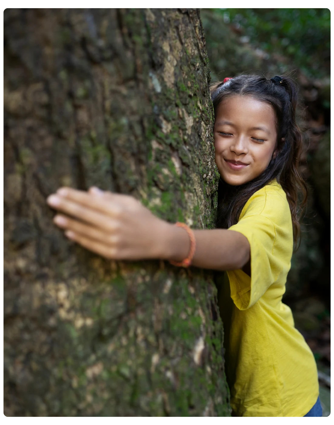 Niña abrazando un árbol, en la sección sobre por qué Compospack fabrica empaque compostable