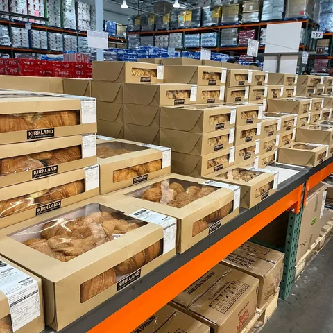 Cajas de panadería de Compospack con ventana de PLA, en anaquel de tienda con producto de marca Kirkland